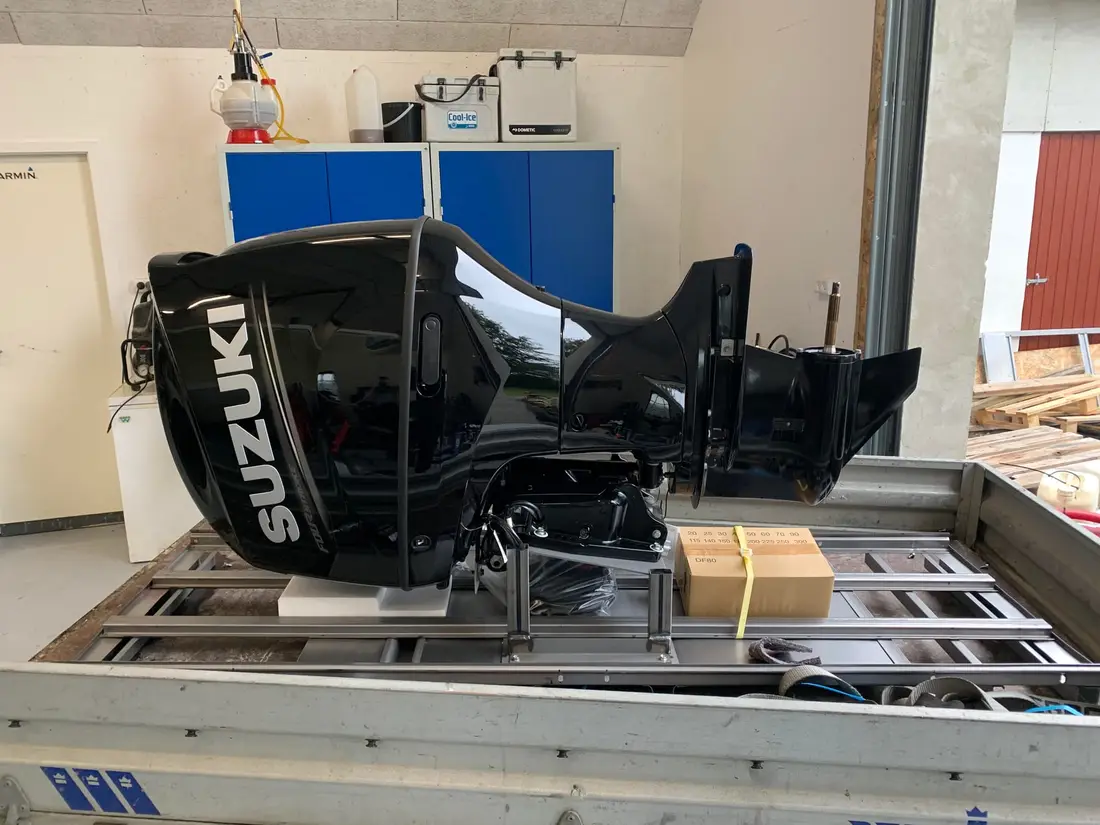 Ny Suzuki-påhængsmotor spændt fast på et stativ i værkstedet